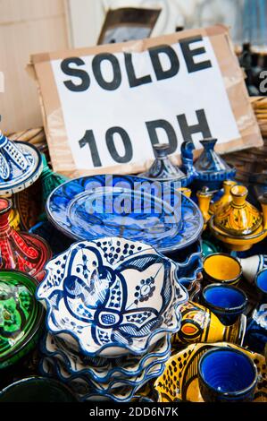 This photo was taken inside the old medina of Essaouira (formerly Mogador), where a healthy variety of items including ceramics, babouches, beads, spices and scarves can be found to be bought as souvenirs. Stock Photo