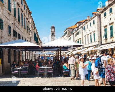 Tourists in a cafe on Stradun with the Franciscan Monastery behind, Dubrovnik Old Town, Croatia Stock Photo