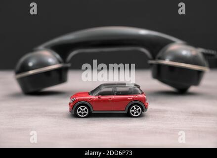 A small Mini (toy) car and a old telephone receiver in the background. Stock Photo