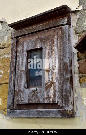 Electricity meter in outside wall in old wooden enclosure, Stock Photo