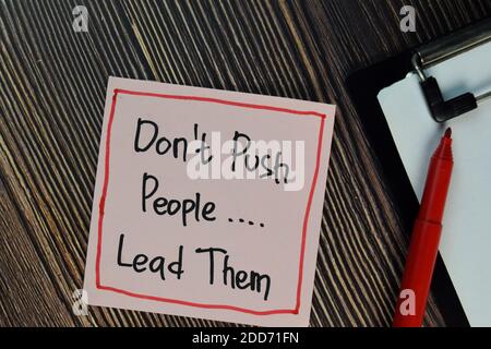 Don't Push People. Lead Them write on sticky notes isolated on Wooden Table. Stock Photo