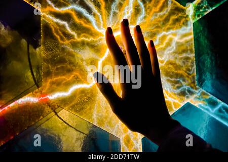 Woman hand touching plasma panel display in dark room of museum - close up view Stock Photo