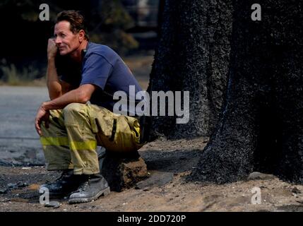 NO FILM, NO VIDEO, NO TV, NO DOCUMENTARY - Mike Corey, a firefighter with Lake Valley, watches his friend and retired firefighter, John Hartzell, sift through the remains of his home that burned in the Angora Fire in South Lake Tahoe, California, June 26, 2007. Photo by Kevin German/Sacramento Bee/MCT/ABACAPRESS.COM Stock Photo