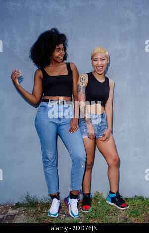 Portrait of two joyful beautiful young women standing together Stock Photo