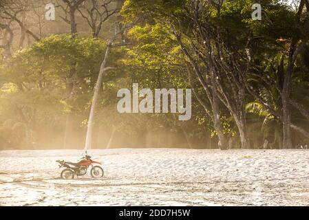 Motorcycle on a beach at sunset, Nosara, Guanacaste Province, Pacific Coast, Costa Rica Stock Photo