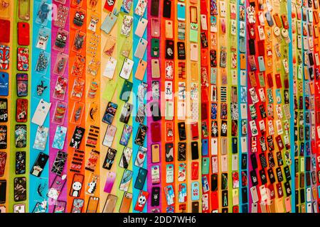 Pile of multicolored plastic back covers for mobile phones in shop. Choice of smart phone protector accessories background. Stock Photo