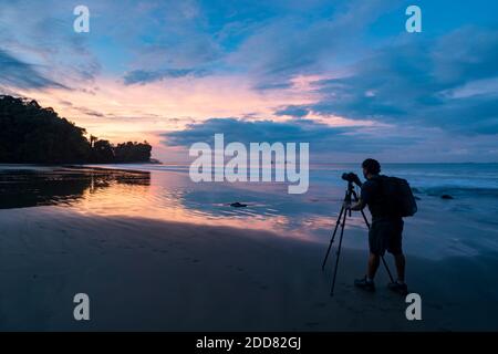 Photographer photographing sunrise at Playa Arco Beach, Uvita, Puntarenas Province, Pacific Coast of Costa Rica Stock Photo