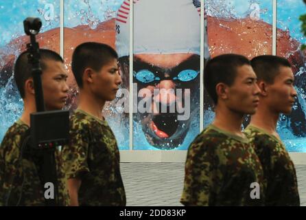 NO FILM, NO VIDEO, NO TV, NO DOCUMENTARY - Security workers walk by a large poster of American swimmer Michael Phelps in the Olympic Park, the day before the opening ceremony of the Games of the XXIX Olympiad in Beijing, China, on August 7, 2008. Photo by Joe Rimkus Jr./Miami Herald/MCT/Cameleon/ABACAPRESS.COM Stock Photo
