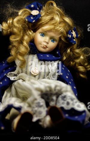 Old ceramic doll with very visible signs of wear. Stock Photo