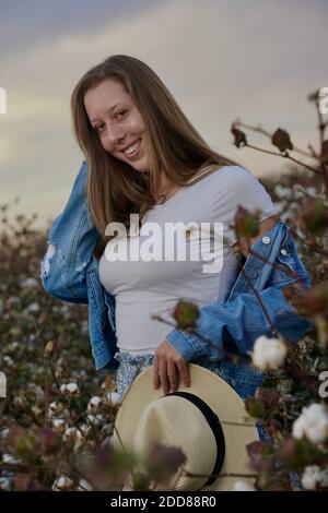 A teenage girl poses in a cotton field. Stock Photo