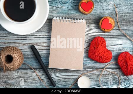 Romantic background with Notepad, coffee Cup and hearts on wooden background. Stock Photo