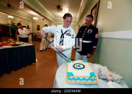 NO FILM, NO VIDEO, NO TV, NO DOCUMENTARY - Navy Petty Officer 2nd Class Desiree Rivers uses her Marine Corps husband's saber to cut her reenlistment cake at the Bayview Club at the U.S. Navy base at Guantanamo Bay, Cuba, on March 27, 2009. Her husband, Marine Staff Sgt. David Rivers, right, wore his dress blues for the occasion. Photo by John VanBeekum/Miami Herald/MCT/ABACAPRESS.COM Stock Photo