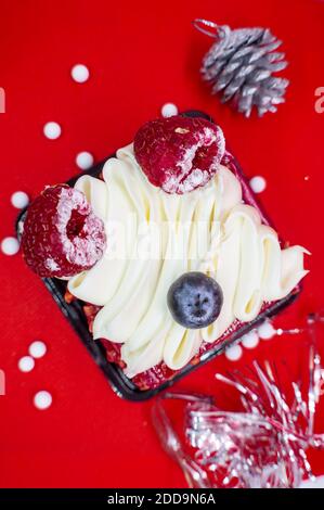 Cake with winter berries and fruit. Red background. The view from the top. Stock Photo