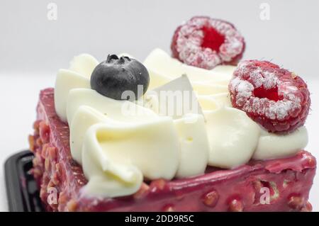 Cream cake with cream and raspberries. A piece of cake with wild berries Stock Photo