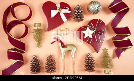 Luxury Christmas background with on trend fashionable stylish coral, deep red and gold gifts and decorations. Top view blog hero header creative compo Stock Photo