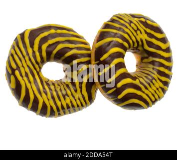 Two American donuts covered with chocolate and with yellow stripes on a white background Stock Photo
