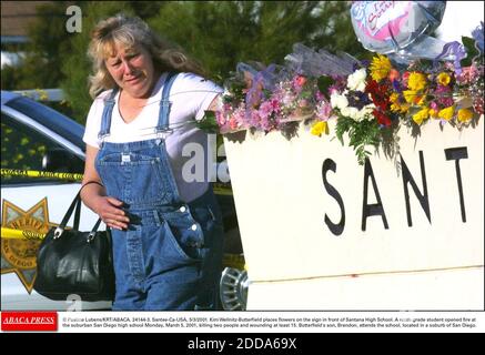 NO FILM, NO VIDEO, NO TV, NO DOCUMENTARY - © Pauline Lubens/KRT/ABACA. 24144-3. Santee-Ca-USA, 5/3/2001. Kim Wellnitz-Butterfield places flowers on the sign in front of Santana High School. A ninth-grade student opened fire at the suburban San Diego high school Monday, March 5, 2001, killing two p Stock Photo