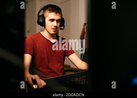 Young man playing video games with computer at desk Stock Photo