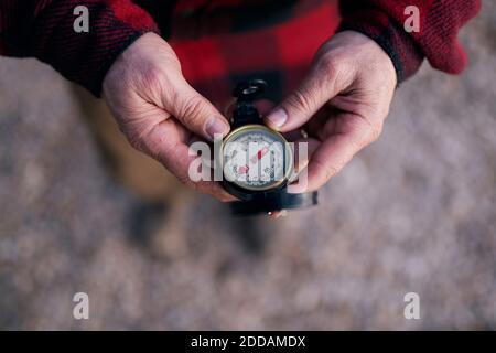 Cropped image of bushcrafter holding navigational compass while hiking Stock Photo