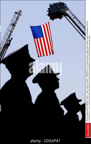 NO FILM, NO VIDEO, NO TV, NO DOCUMENTARY - © Dai Sugano/KRT/ABACA. 37941-1. San Jose-CA-USA, 11/09/2002. An American flag is seen behind San Jose firefighters duringa ceremony to remember the heroism exhibited during the terrorist attacks on the United States one year ago. Stock Photo