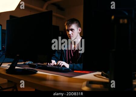 Young computer hacker working while sitting at office Stock Photo