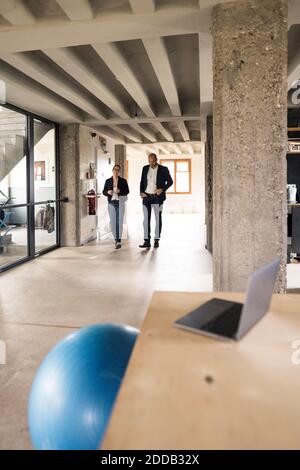 Business people talking while walking in office Stock Photo