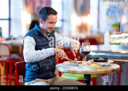 Young man having lunch while sitting in restaurant Stock Photo