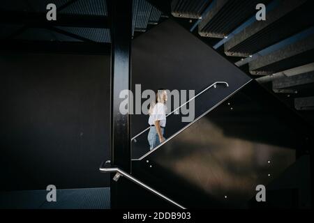 Young woman climbing on steps Stock Photo