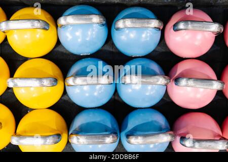 Close-up of colorful kettlebells on table in gym Stock Photo