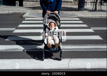 Father with baby in baby stroller crossing road in city Stock Photo