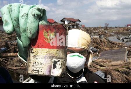 NO FILM, NO VIDEO, NO TV, NO DOCUMENTARY - Indonesian Red Cross volunteer Ridhwan holds up the ID card of a 20-year-old female tsunami victim, recovered from her corpse on Sunday, January 16, 2005. Most corpses are unidentified because they were buried in mass graves. Photo by Norman NG/Kansas City Star/KRT/ABACA. Stock Photo