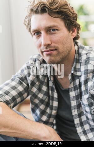 Serious mid adult man sitting at home Stock Photo