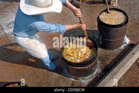 NO FILM, NO VIDEO, NO TV, NO DOCUMENTARY - Part-time cowboy Wayne Saur stirs up a large pot of stew at Trinity United Methodist Church in Gulfport, Texas on September 16, 2005. Saur joined a group of volunteers from Comfort, Texas, that left their ranch to cook for Hurricane Katrina relief workers and others the old fashioned way - over an open fire. Photo by Chris Myers/St. Paul Pioneer Press/KRT/ABACAPRESS.COM. Stock Photo