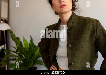 Female model wearing jacket standing against wall Stock Photo