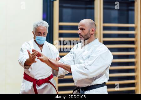 Instructor teaching karate to male student in class Stock Photo
