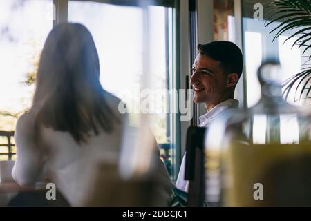 Smiling man talking with woman while sitting at home Stock Photo