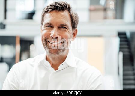 Smiling mature male engineer in factory Stock Photo