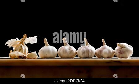 Garlic bulbs shot on a marble table top in a fun way as if the garlic bulb on the left is preaching to his flock Stock Photo