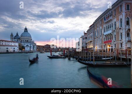 Italy, Veneto, Venice, Gondolas moored in marina in front of Santa Maria della Salute at dusk