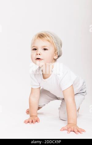 Cute little toddler girl crawling in studio against white background Stock Photo