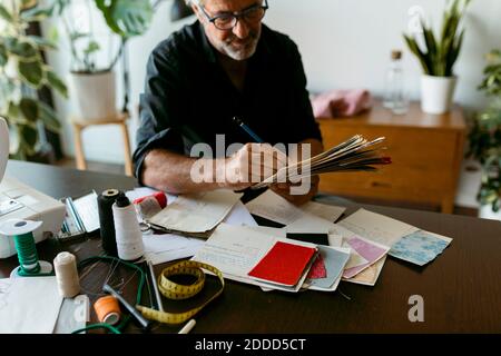 Male costume designer working at table in studio Stock Photo