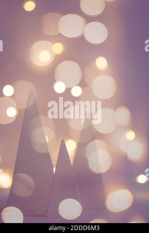 blurred holiday background with christmas trees and bokeh garland lights Stock Photo