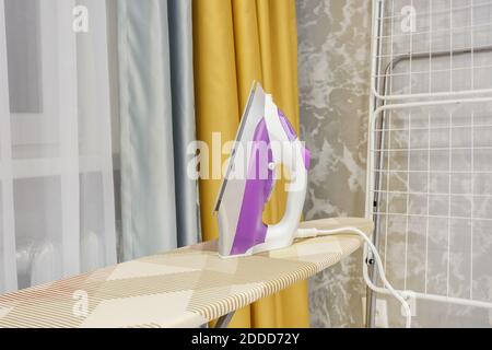 modern iron on ironing board Stock Photo