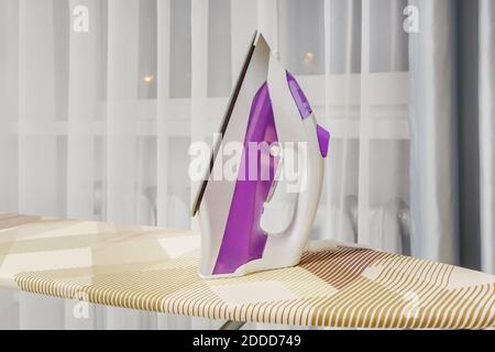 modern iron on ironing board Stock Photo