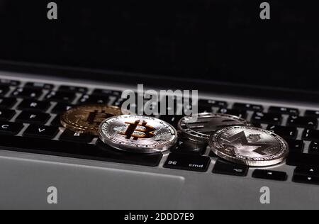 Gold and silver bitcoins, monero and litecoin coins on laptop keyboard, new digital virtual money, stacks of cryptocurrencies coins Stock Photo