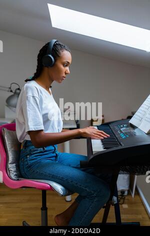 Young girl playing piano at home Stock Photo