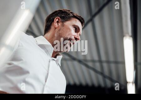 Low angle view of mature businessman looking away in industry Stock Photo