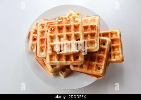 Plain waffles on a while plate against a white background Stock Photo