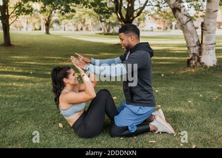 Man and woman giving high five while exercising at backyard Stock Photo