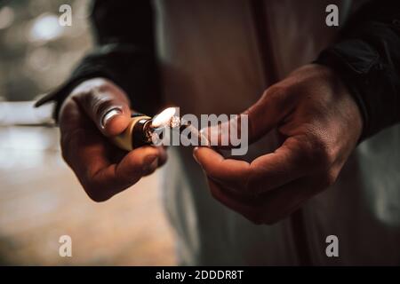Close-up of man lighting cigarette with lighter Stock Photo
